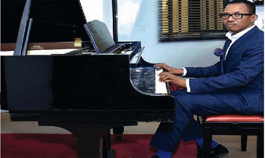 Ajulo playing the grand piano in his office